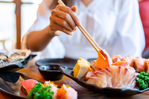 日本料理店で刺身を食べる女性