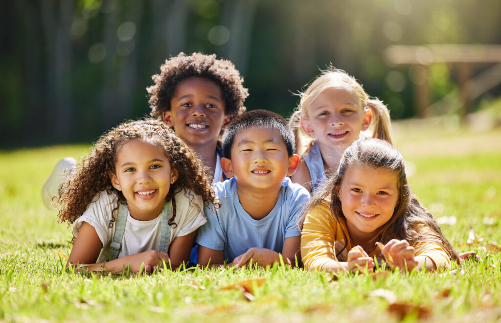 Shot of a group of kids laying on the grass outside